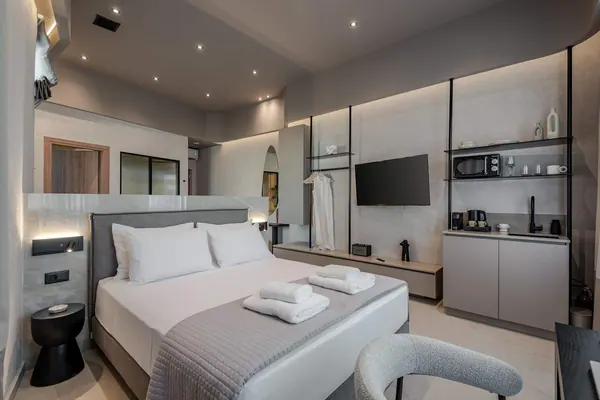 King-size bed with kitchenette behind, Amara Luxury Suite with City Balcony