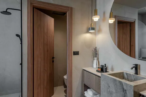 Bathroom with stone basin and round backlit mirror, Amara Luxury Suite with Terrace