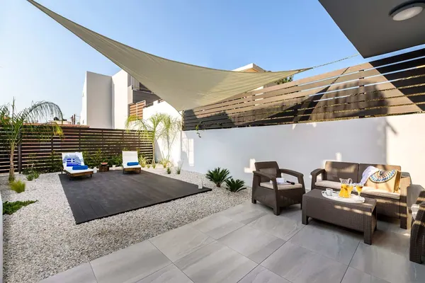 Private courtyard with shade sail, sunbeds and lounge seating, Solar Ground Apartment, Agia Marina