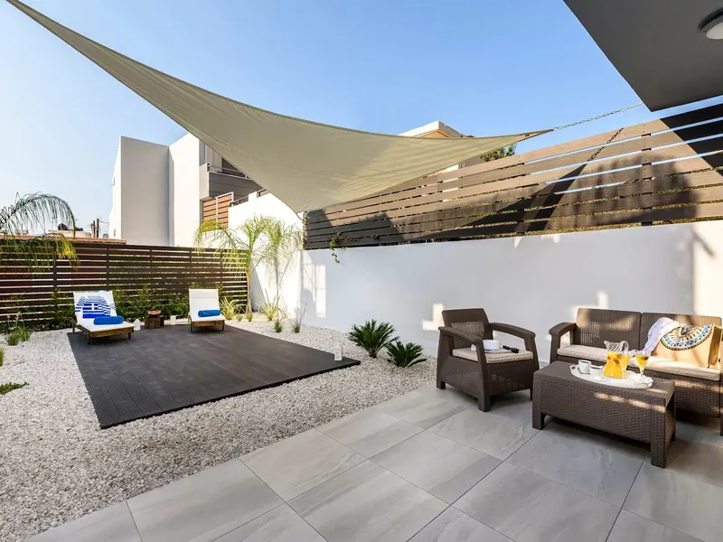 Private courtyard with shade sail, sunbeds and lounge seating, Solar Ground Apartment