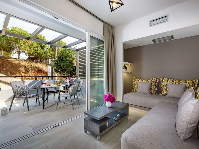 Living area opening onto the shaded balcony, Solar Apartments, Agia Marina