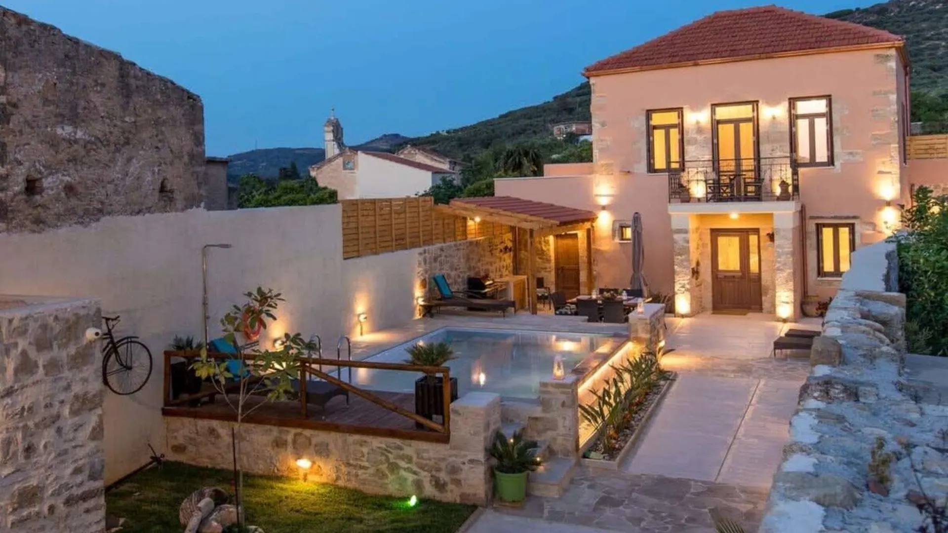 Villa Theta exterior and landscaped garden lit in the evening, Drapanias Crete