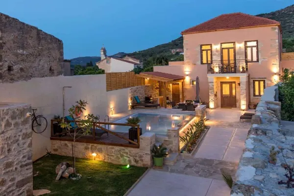 Villa Theta exterior and landscaped garden lit in the evening, Drapanias Crete