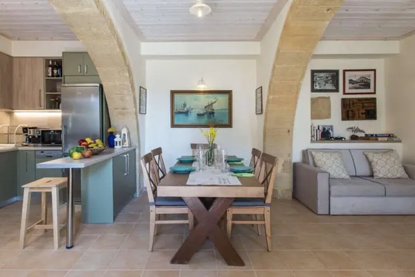 Fully equipped kitchen with dining table and sofa, Villa Theta by Amara Living