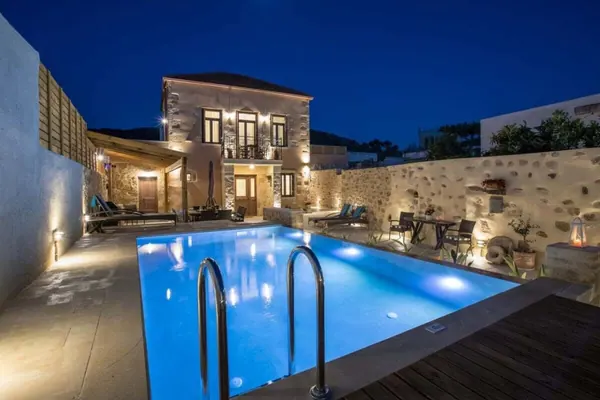 Stone-built Villa Theta and private pool lit at dusk, Drapanias, Kissamos