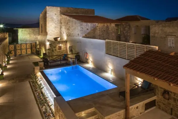 Private pool beside the stone villa at night, Villa Theta by Amara Living
